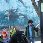 Garth Martens reads to Robert Wyland orca mural.